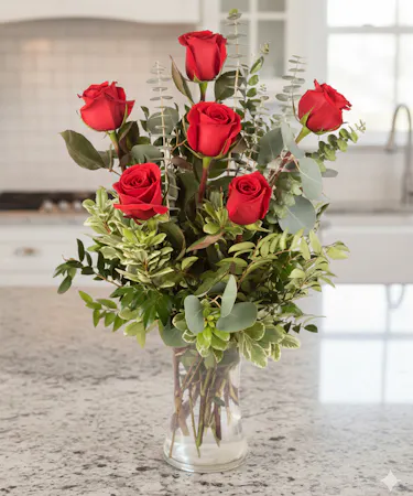 6 red roses in a clear glass vase