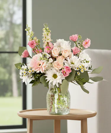 White and pink floral arrangement with gerbera daisies, spray roses, daisy mums, lisianthus and larkspur